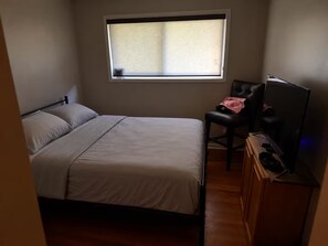 A bedroom with a single bed, a chair, a television, and a window. - Superb 3-bedroom house with AC in vibrant Atlanta (Atlanta)
