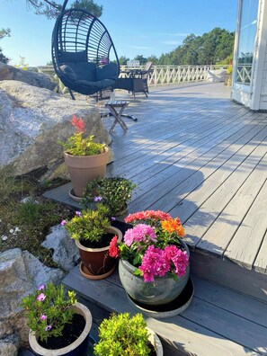 A wooden deck with potted plants and outdoor furniture. - Cabin near Tveitafossen and Fitjarfjellet (Fitjar)