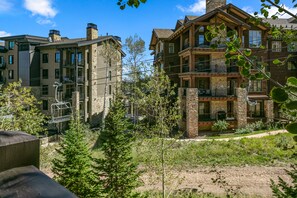 A multi-story building with stone and wood exterior, balconies, and a ski lift in the background. - Flagstaff Lodge at Deer Valley Resort - Three Bedroom Residence #304 3 Condo (Park City)