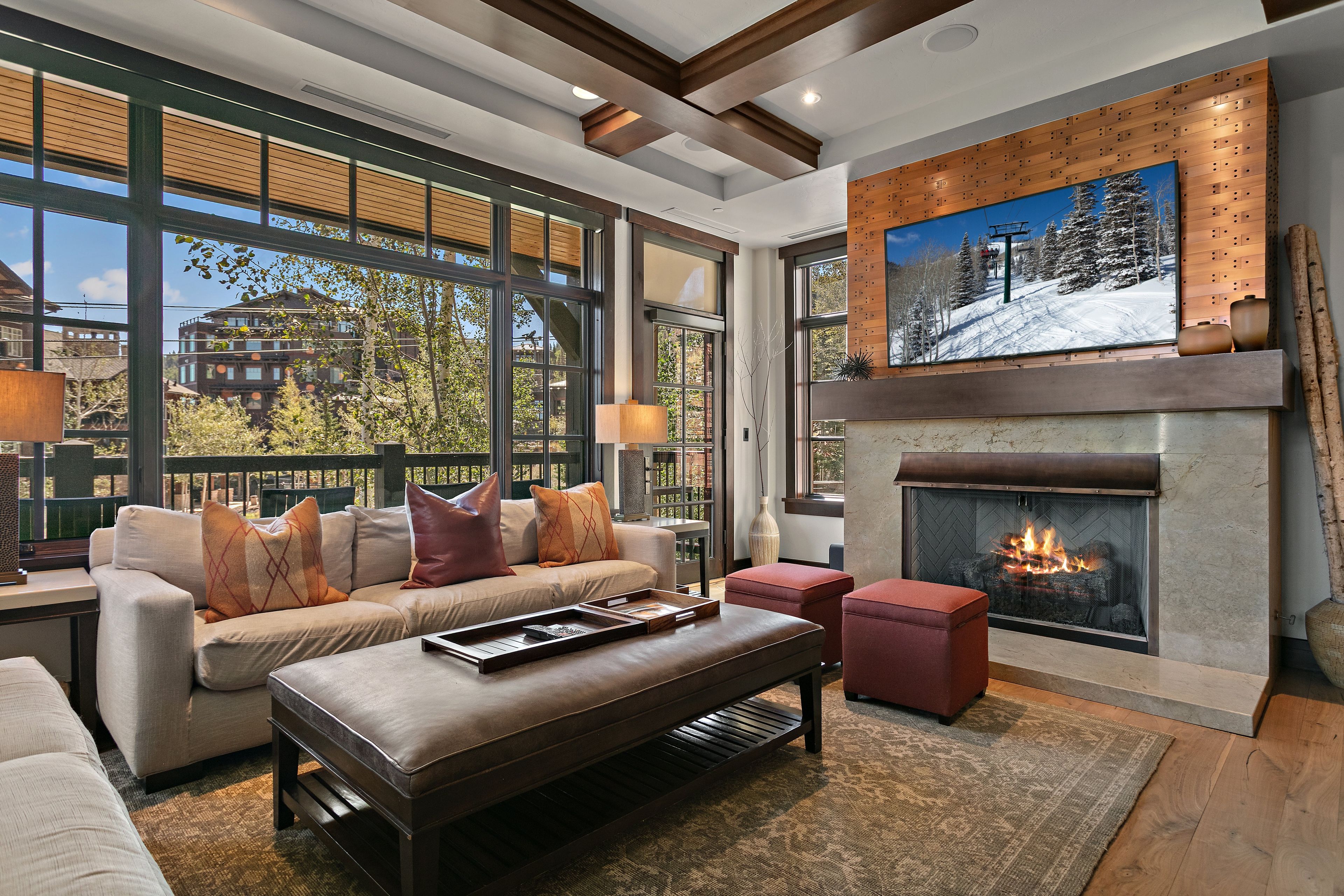A modern living room with a fireplace, large windows, and a cozy seating area.