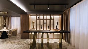 A modern dining area with a marble floor, a central table, and a wine display cabinet.