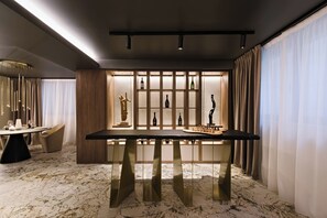 Una zona menjador moderna amb terra de marbre, una taula central i un vitrine per a vins.
