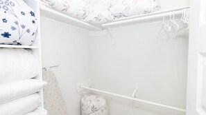 A white closet with hanging clothes and a folded blanket. - New 3br Townhome, Heated Pool, Beach Steps Spi 3 Bedroom Townhouse (South Padre Island)