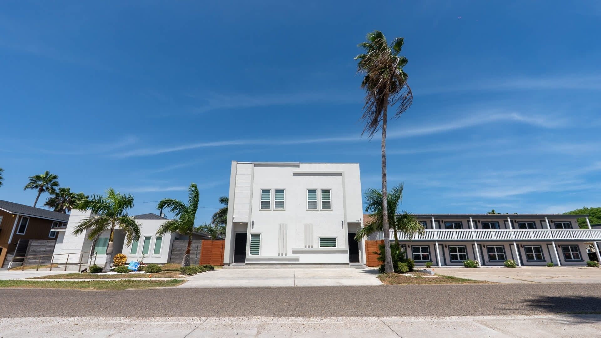 Um edifício moderno com telhado plano, janelas retangulares e entrada central.
