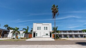 Um edifício moderno com telhado plano, janelas retangulares e entrada central.