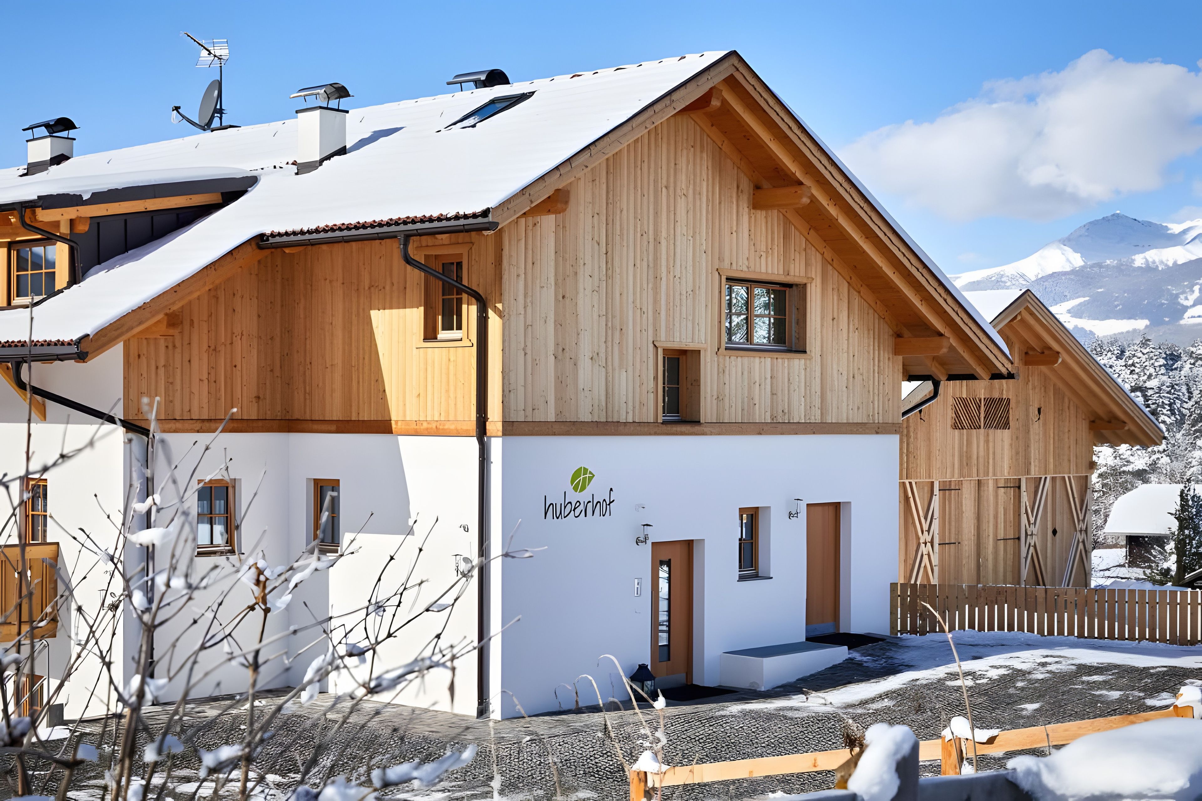 Eine Holzhütte mit geneigtem Dach, einem sichtbaren Eingang und einem Berg im Hintergrund.