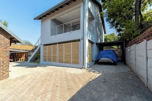 A modern two-story house with a covered outdoor area and a carport. - M&M FB Solar Powered Home Pet Friendly (Edenvale)