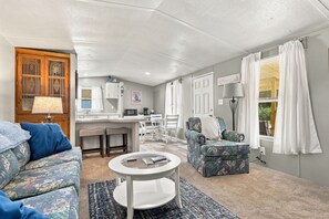 A compact living space with a kitchenette, a sofa, a chair, and a coffee table. - A Cozy Place - Country/Beach Living (Beaufort)