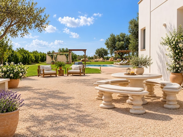 A patio area with outdoor furniture, a pool, and a garden.
