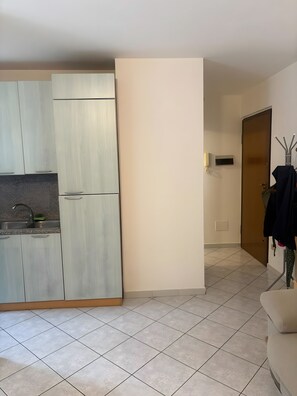 A compact kitchen with a sink, cabinets, and a door leading to another room. - Apartment 'Peak De Viou Aosta' with Balcony and Wi-Fi (Aosta)