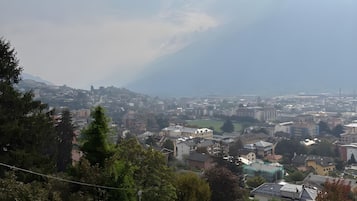 Un quartier résidentiel offrant une vue sur une ville lointaine, entouré de verdure et délimité par une clôture en bois.