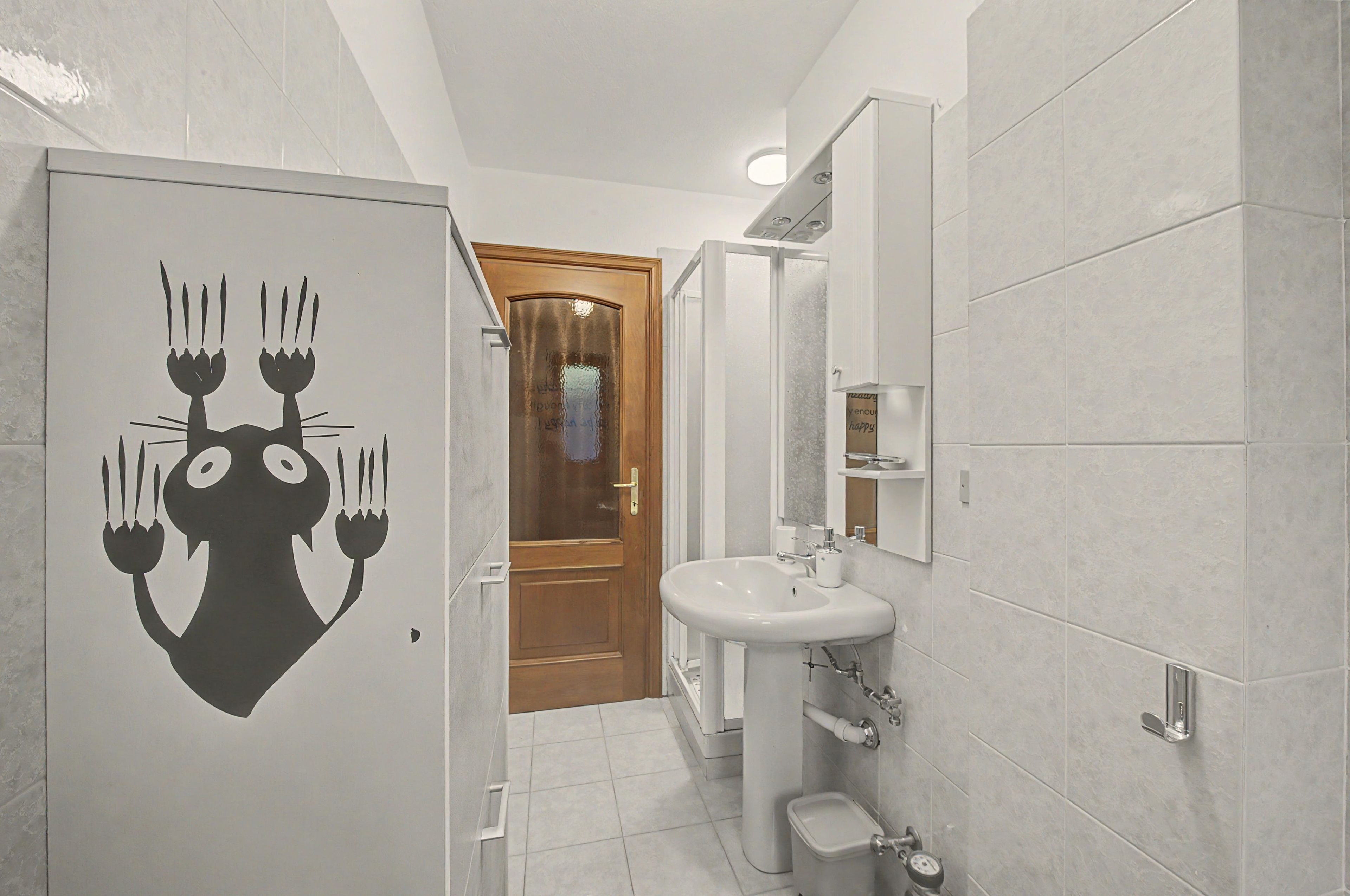 A bathroom with a sink, toilet, and a mirror.