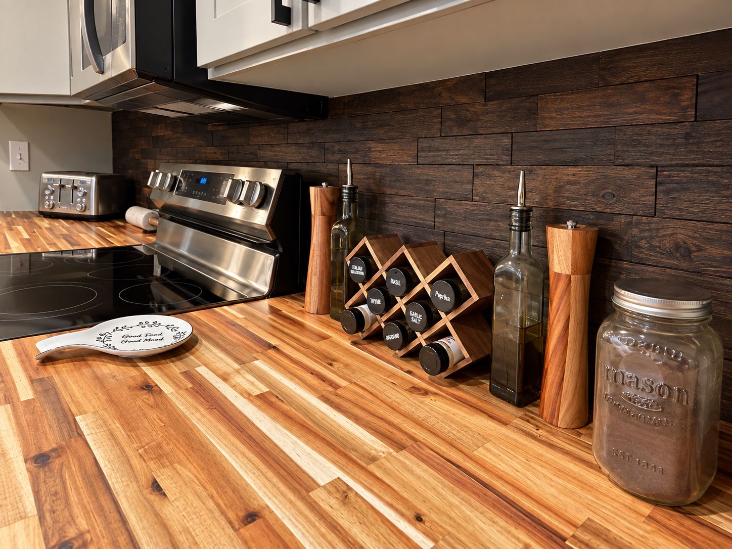 A kitchen with a wooden countertop, stainless steel appliances, and a spice rack.