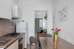 Una cucina moderna con piano cottura a gas, mobili bianchi e forno integrato.