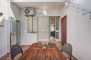 An outdoor patio with a wooden table, two chairs, and a potted plant. - Holiday Home 'Blue Wave' (Porto Cesareo)