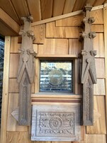 Una estructura de madera con detalles tallados y un ventanal enmarcado.