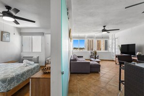A modern apartment with a bedroom, living area, and balcony. - Oceanview Penthouse | Huge Private Terrace (Luquillo)