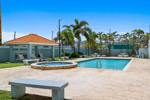 A swimming pool with a sunken hot tub, lounge chairs, and a covered seating area. - Oceanview Penthouse | Huge Private Terrace (Luquillo)