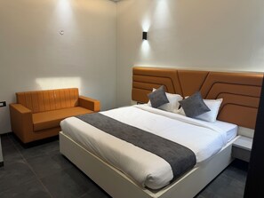 Ein Schlafzimmer mit einem Bett, einem Sofa und einer Wandleuchte.