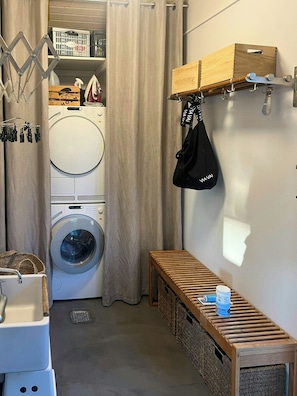 A laundry room with a washing machine, drying rack, and a bench with storage. - Idyll and charm with views over the fjord (Kalundborg)