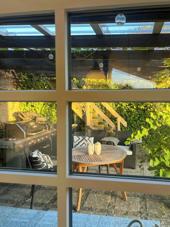 A glass-enclosed patio with a grill, outdoor seating, and a pergola. - Idyll and charm with views over the fjord (Kalundborg)
