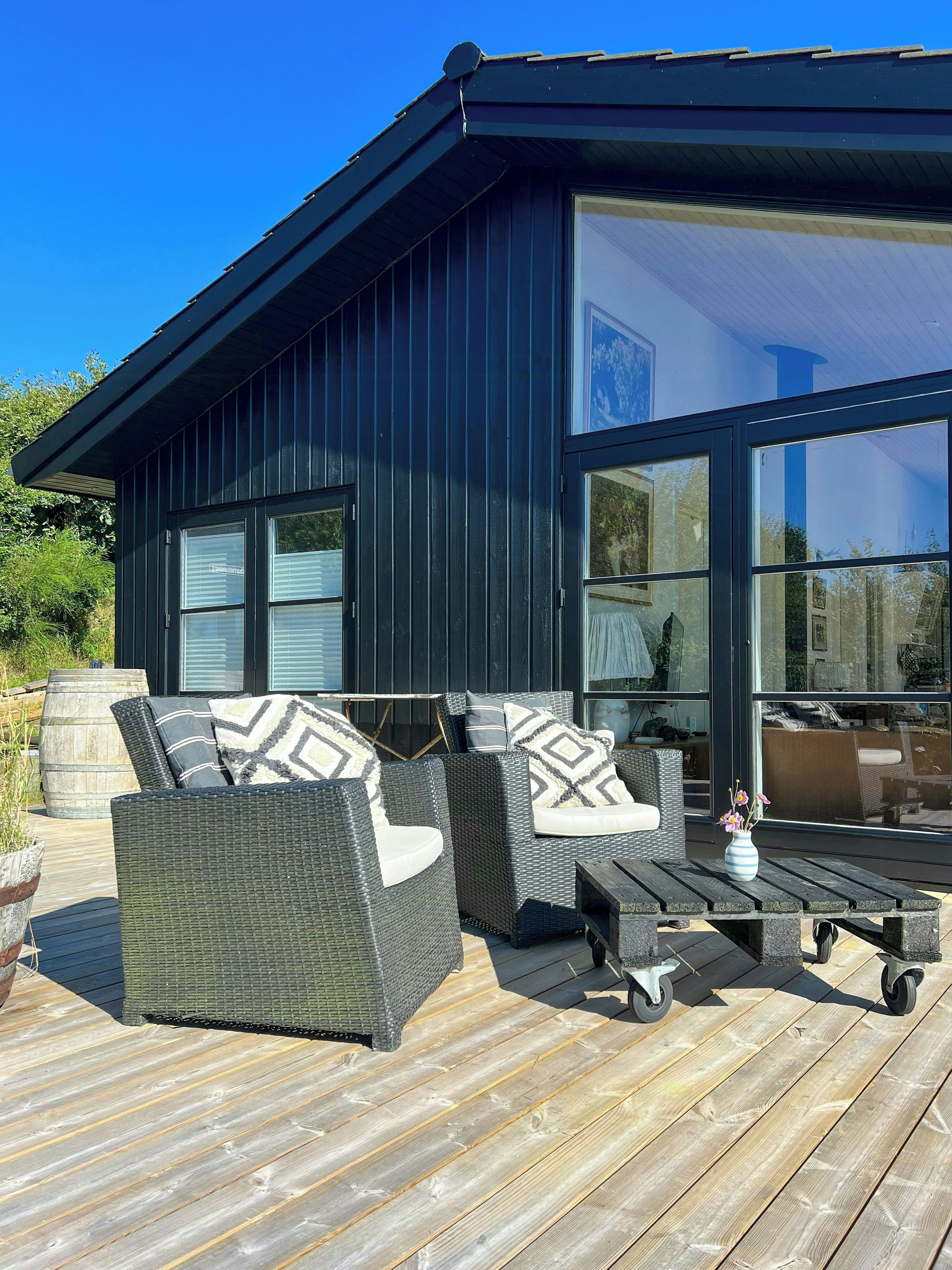 A modern outdoor seating area with wicker furniture and a wooden deck.
