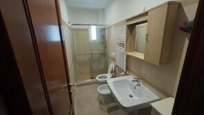 A bathroom with a glass shower enclosure, a toilet, and a sink. - Vatican Doli (Roma)