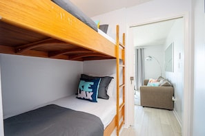 A bunk bed room with a small desk and a door leading to a living area. - Summer Breeze 310 (Miramar Beach)