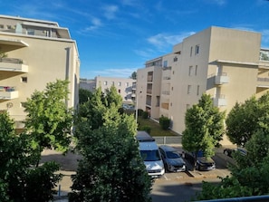 A residential area with multi-story buildings, a parking lot, and trees. - Charming apartment near downtown (Avignon)
