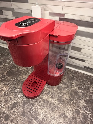 A red coffee machine with a digital interface, a transparent water container, and a foot pedal. - Stylish Studio in St Boniface: French Quarter - cafés, museums, bus route, park (Winnipeg)