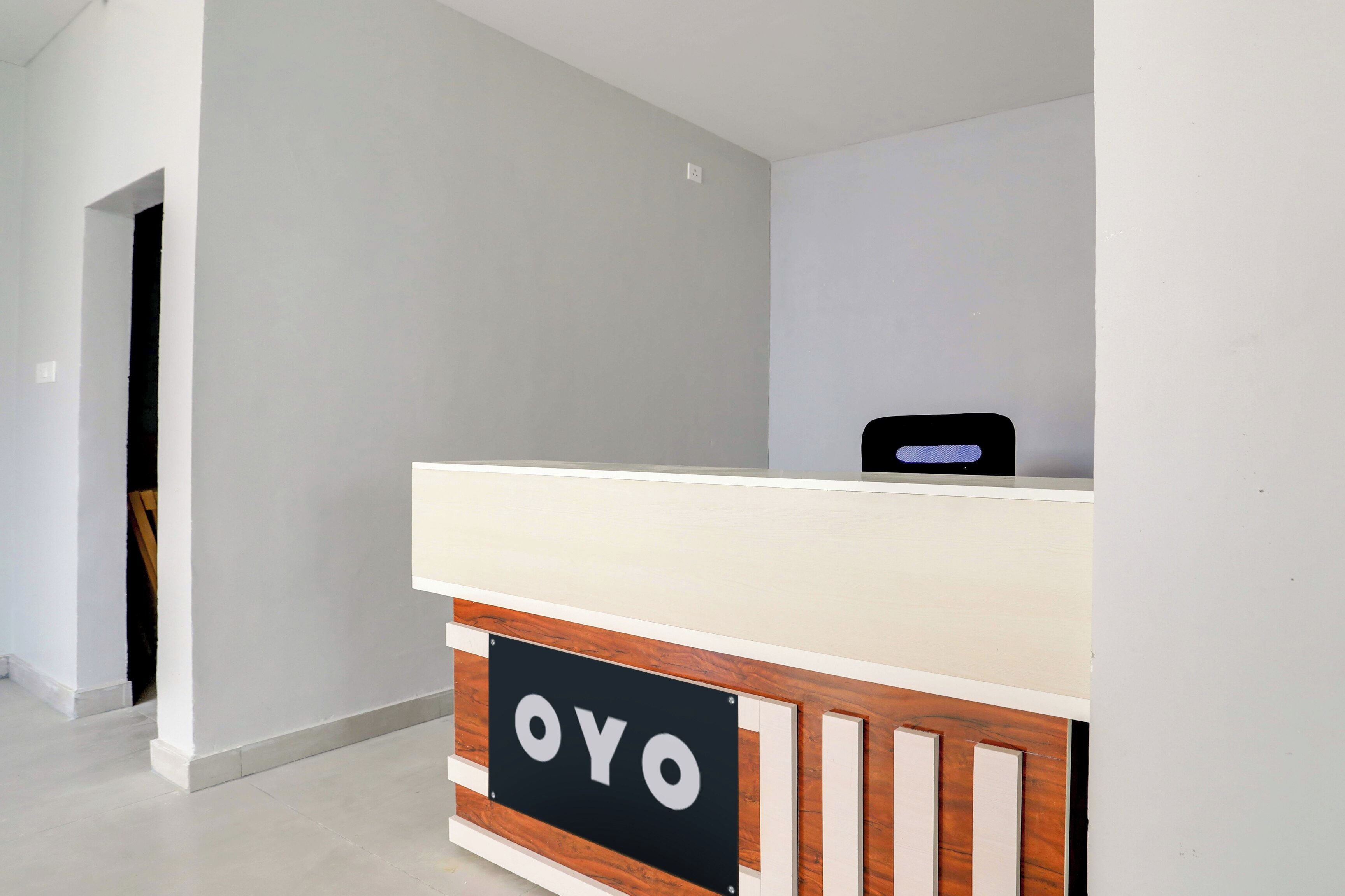 Una mesa de recepción con un cartel que dice 'OYO' en el vestíbulo de un hotel.