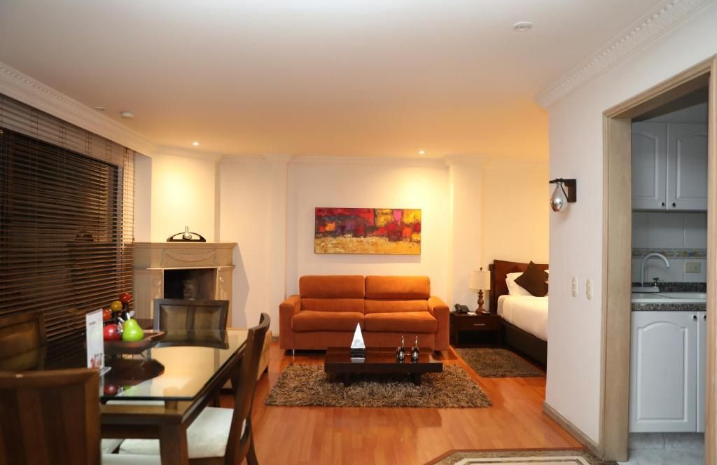 Ein gemütlicher Wohnbereich mit Sofa, Esstisch und einem Gemälde an der Wand.