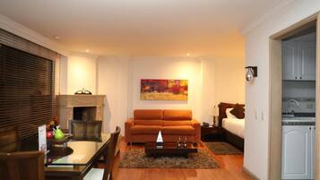 Ein gemütlicher Wohnbereich mit Sofa, Esstisch und einem Gemälde an der Wand.