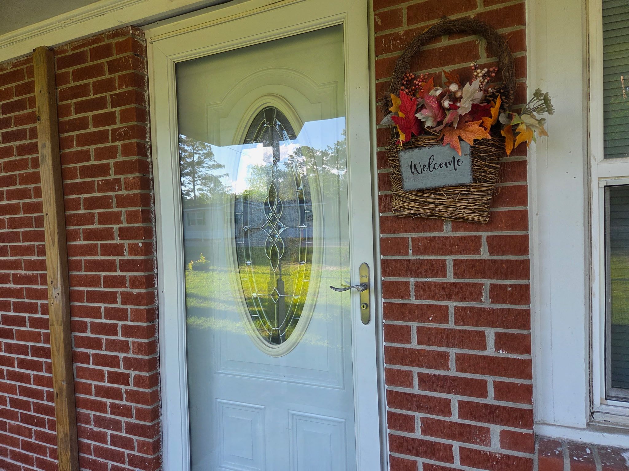 A white door with a glass panel and a 'Welcome' sign above it.