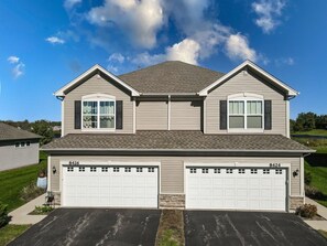 A two-story house with a garage, numbered 8426 and 8424, featuring a gabled roof and a front yard.