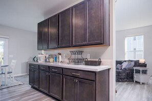 A kitchen with dark cabinets, a white countertop, and various kitchen items. - Wonder Lake Extended Stay 6-Month+ 2/2 Rental Home (Wonder Lake)