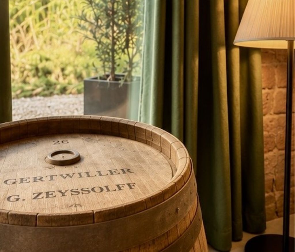 Un tonneau en bois orné d’inscriptions, une fenêtre avec des rideaux et une lampe.