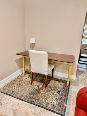 A corner room with a wooden desk, a white chair, a lamp, and a patterned rug. - Charming corner home on Lakeview Dr., near historic Circle and public beach (Sebring)
