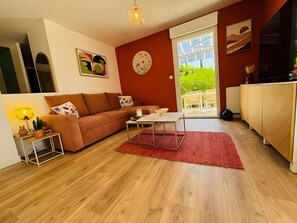 A living room with a sofa, coffee table, and a dining area with chairs.