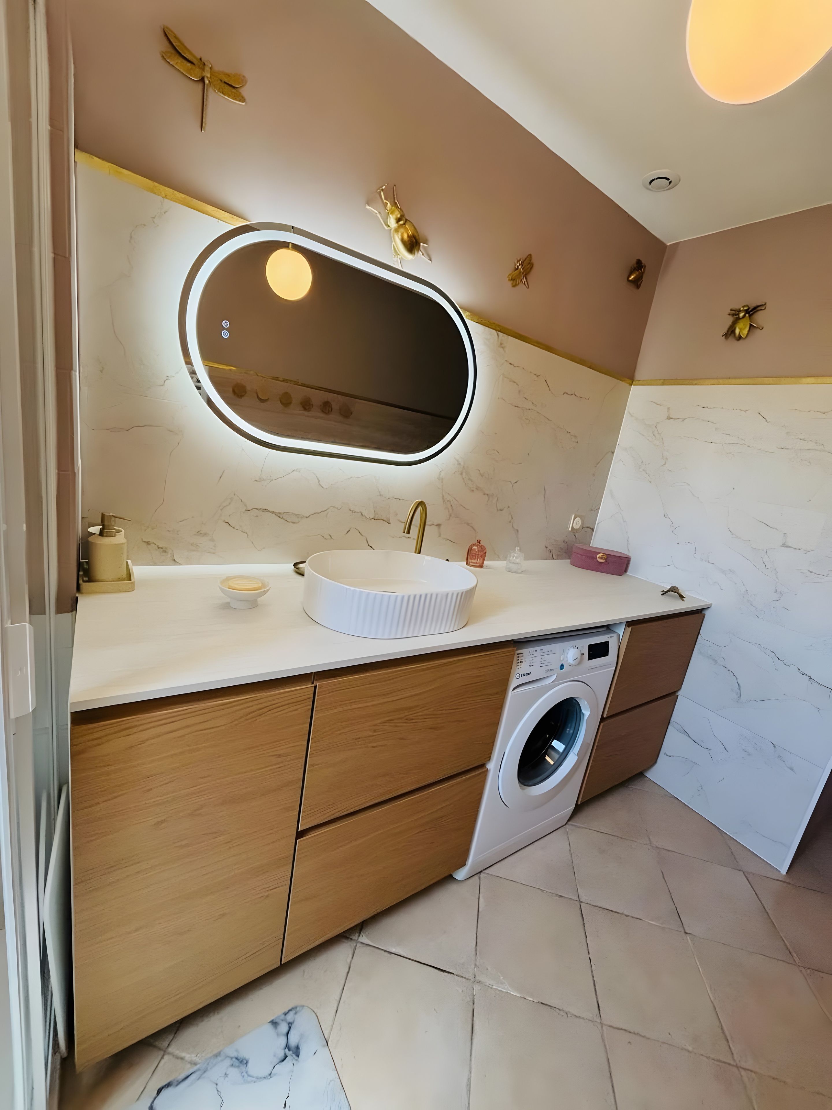 Ein modernes Badezimmer mit Waschbecken, Spiegel und Waschmaschine.