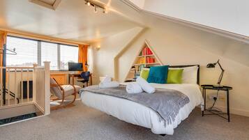A bedroom with a bed, a desk, a chair, a bookshelf, and a window.