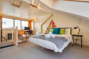 Ein Schlafzimmer mit einem Bett, einem Schreibtisch, einem Stuhl, einem Bücherregal und einem Fenster.