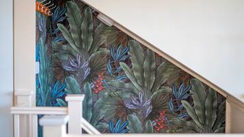 A staircase with a tropical leaf pattern wallpaper.