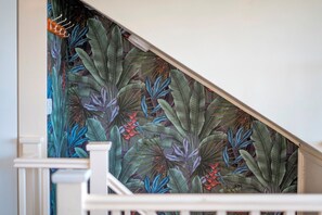 A staircase with a tropical leaf pattern wallpaper. - Charming & Spacious Flat over 2 Floors on Mill Rd - Pass the Keys (Cambridge)
