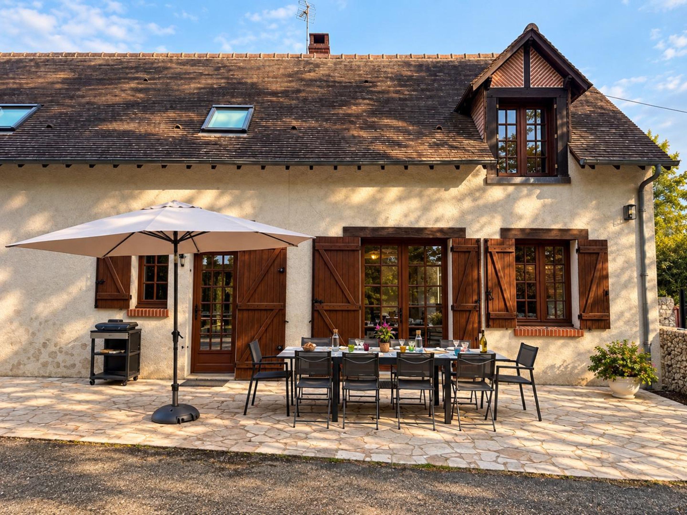 A rustic building with a stone facade, wooden shutters, and a tiled roof.