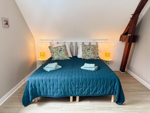 A bed with a teal bedspread, two pillows, and two bedside lamps. - House, parking, pets allowed - 9 guests (Ouchamps)