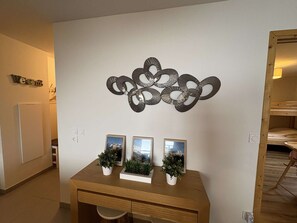 A room with a wooden desk, three framed pictures, and a wall-mounted decorative piece. - Apartment with south-facing balcony, mountain view - 6 guests (Auris)