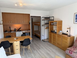 Ein kompakter Wohnbereich mit Küchenzeile, einem Essbereich und einer Sitzecke mit Sofa.