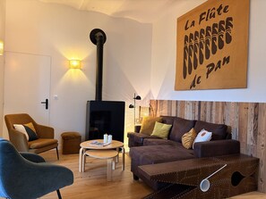 A cozy living room with a fireplace, a sofa, a chair, and a coffee table. - Cozy apartment in Villard-de-Lans - 6 guests (Villard-de-Lans)