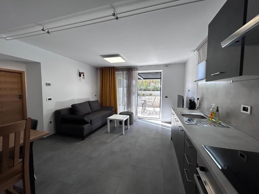A modern kitchen with a built-in oven and a dining area with a wooden table and chairs.